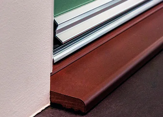 Close-up of a two-part synthetic door sill showing the aluminium threshold and moulded sill profile