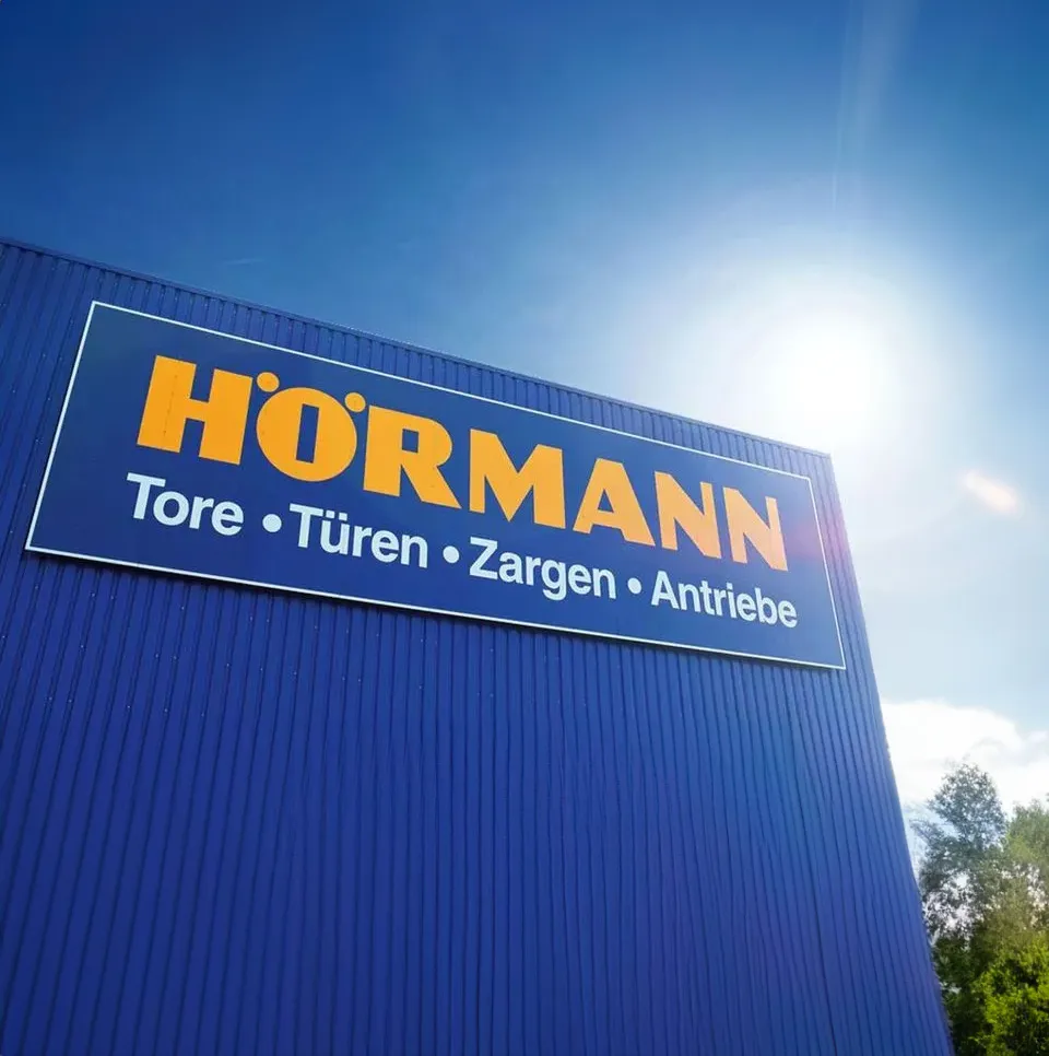 Hörmann signage on the blue factory building of the Hörmann Group